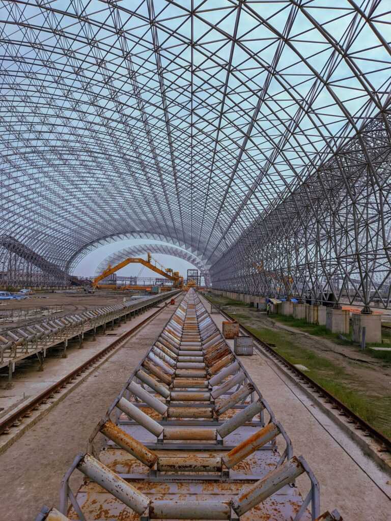 A vast, rusty steel truss structure in Rampal, Bangladesh, depicting industrial architecture.